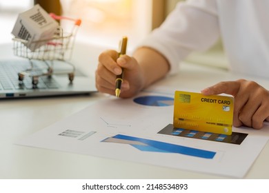 Close-up Of Business Holding Credit Card To Check Account Balance Use An Online Banking App On Your Laptop. Online Payment Typewriter Hand Shopping Keyboard On The Notebook