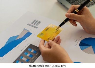 Close-up Of Business Holding Credit Card To Check Account Balance Use An Online Banking App On Your Laptop. Online Payment Typewriter Hand Shopping Keyboard On The Notebook