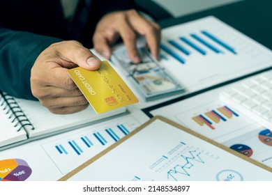 Close-up Of Business Holding Credit Card To Check Account Balance Use An Online Banking App On Your Laptop. Online Payment Typewriter Hand Shopping Keyboard On The Notebook