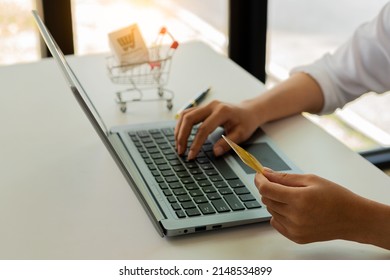 Close-up Of Business Holding Credit Card To Check Account Balance Use An Online Banking App On Your Laptop. Online Payment Typewriter Hand Shopping Keyboard On The Notebook