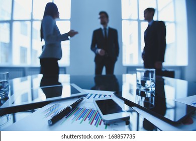 Close-up of business objects at workplace on background of office workers interacting - Powered by Shutterstock