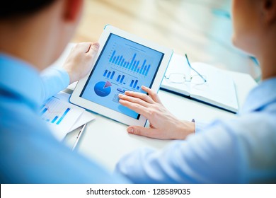 Close-up of business partners looking at business document in touchpad - Powered by Shutterstock