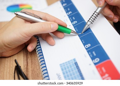 Close-up Of Business People  Discussing  About A Date On Calendar To Schedule A Meeting