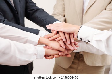 Close-up of business people standing and holding hands they working in team and support each other in business - Shutterstock ID 1458084476