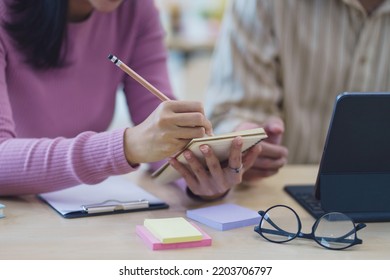 Close-up of business people taking note at a meeting on clipboard for drafting, writing meeting minutes in office and printing on computer. - Shutterstock ID 2203706797
