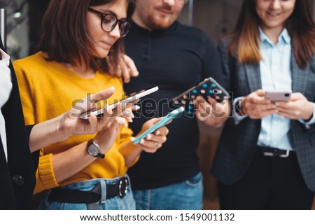 Close-up of  business people working together and using modern smartphone at office. Digital gadgets using concept