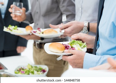Closeup Of Business People's Hands Having Lunch Together