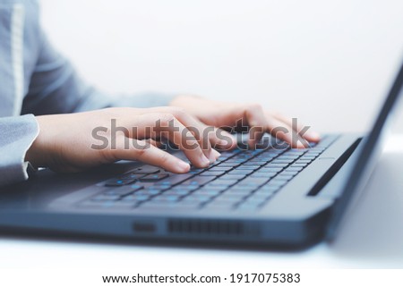 close-up of business woman hand typing and using laptop keyboard for searching with technology networking on working and job on desk at work place or work at home.