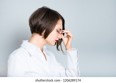 Closeup Of Business Woman Has Pain Nose, Short Hair Cut, Isolated Over Gray Background