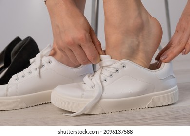 Close-up Business Woman Takes Off Her Shoes Puts On White Leather Sneakers.