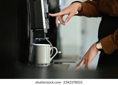 Closeup business woman using coffee machine in the office.