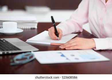 Closeup Of A Business Woman Writing In A Notebook