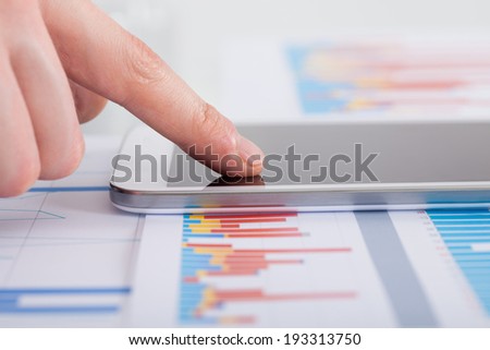 Closeup of businessman analyzing bargraph at desk