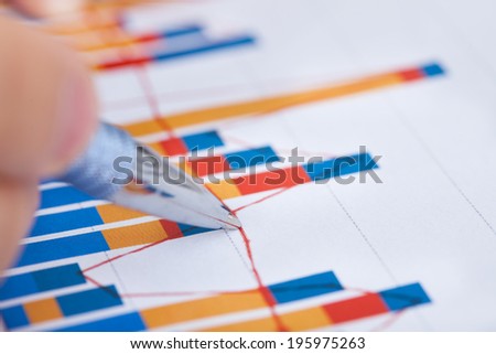 Closeup of businessman analyzing bargraph in office