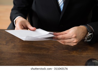 Close-up Of Businessman With Envelopes At Desk In Workplace - Shutterstock ID 311043176