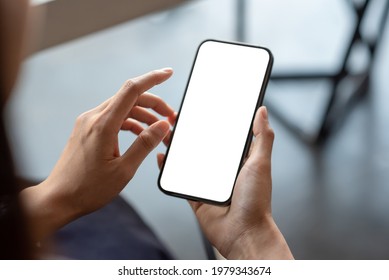 Close-up of a businessman hand holding a smartphone white screen is blank the background is blurred.Mockup. - Shutterstock ID 1979343674
