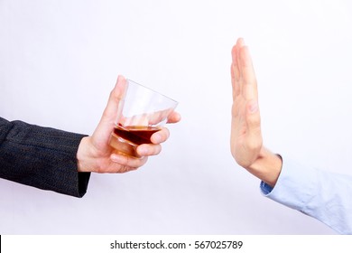 Close-up of businessman hand rejecting glass of whisky offered by businessperson