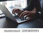 Closeup of businessman hand typing on laptop computer at office. Business man working on computer device, searching the information, surfing the internet on table at workplace