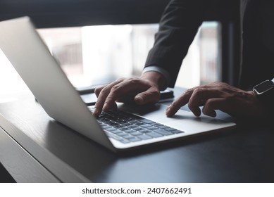 Closeup of businessman hand typing on laptop computer at office. Business man working on computer device, searching the information, surfing the internet on table at workplace - Powered by Shutterstock