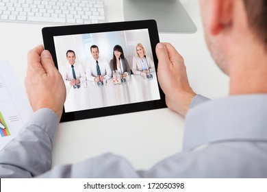 Close-up Of Businessman Looking At Video Conference On Digital Tablet - Powered by Shutterstock