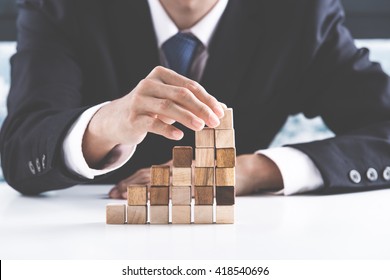 Closeup of businessman making a pyramid with empty wooden cubes - Shutterstock ID 418540696