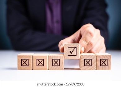 Closeup businessman pick a correct wood cube with many wrong cubes in a row - Shutterstock ID 1798972333