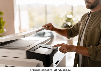 Close-up of a businessman scanning documents using a modern multifunction printer in a bright office, showcasing efficiency and modern technology in a professional setting. Technology concept