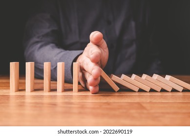 Closeup businessman stop the crash of domino effect on the table