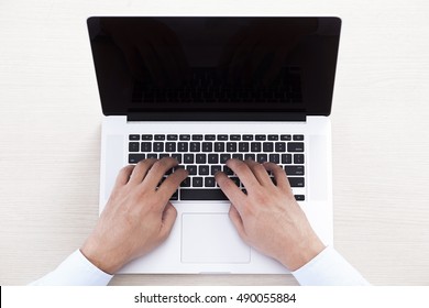 Closeup of businessman typing on laptop computer. Male hands on laptop
