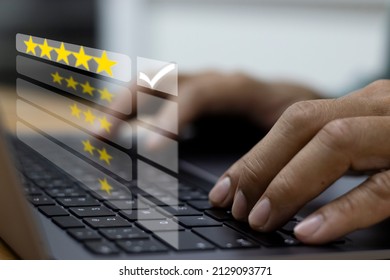 Close-up Of Businessman Typing On Notebook Computer Keyboard Showing Screen Star Icon And Check Mark,Customer  Service Satisfaction Survey  Concept.