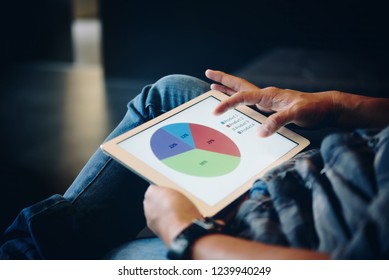 Close-up of businessman using tablet checking for project in office.