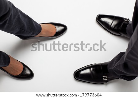 Closeup of businessman's and businesswoman's legs on the floor