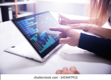 Close-up Businessman's Hand Pointing Bar Graph On Laptop Screen Over White Desk At Workplace - Powered by Shutterstock