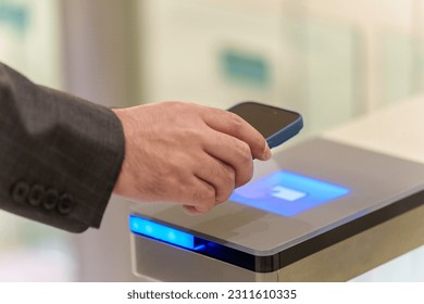 closeup of businessman's hand using a smartphone to pass through a security gate - Powered by Shutterstock