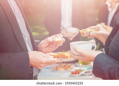 Closeup Of Businesspeople Eating Coffee And Sandwiches During Outdoor Business Lunch