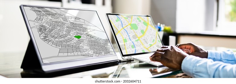 Close-up Of A Businessperson Analyzing Cadastre Map On Computer In The Office