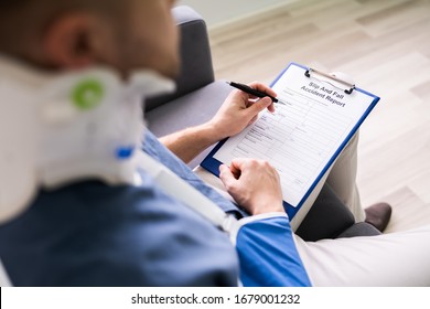 Close-up Of A Businessperson With Broken Arm Filling Health Insurance Claim Form