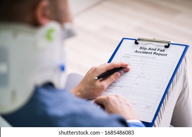 Close-up Of A Businessperson With Broken Arm Filling Health Insurance Claim Form