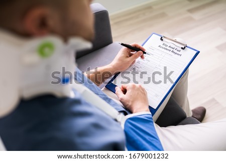Close-up Of A Businessperson With Broken Arm Filling Health Insurance Claim Form