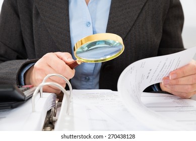 Close-up Of Businessperson Checking Bills With Magnifying Glass - Shutterstock ID 270438128