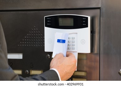 Close-up Of Businessperson Hands Inserting Keycard In Security System To Unlock Door