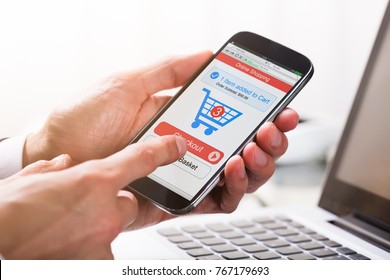 Close-up Of A Businessperson's Hand Clicking On Checkout Option While Shopping On Mobile Phone