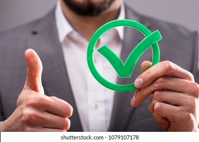 Close-up Of A Businessperson's Hand Holding Green Check Mark Icon - Shutterstock ID 1079107178