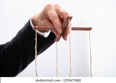 Close-up Of A Businessperson's Hand Manipulating Marionette With A String 