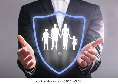 Close-up Of A Businessperson's Hand With Shield Protecting Family - Powered by Shutterstock