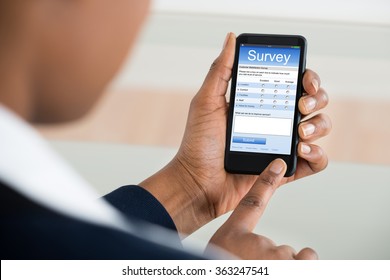 Close-up Of A Businesswoman Filling Online Survey Form On Mobile Phone