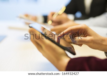 Close-up of Businesswoman hands working with digital tablet during a meeting