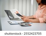 A close-up of a businesswoman working on a laptop in an office. As an accountant, she records financial data, verifies documents, manages income and expenses, ensuring accurate financial reporting