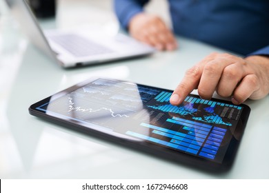 Close-up Of A Businesswoman's Hand Analyzing Graph On Digital Laptop At Workplace - Powered by Shutterstock