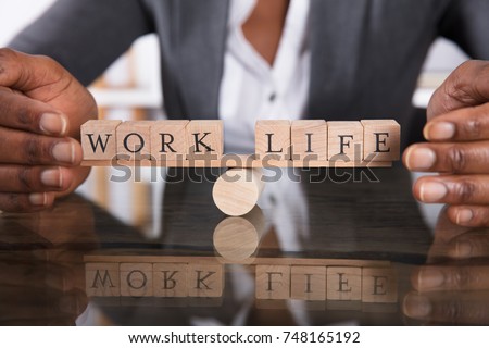 Close-up Of A Businesswoman's Hand Covering Balance Between Life And Work On Seesaw